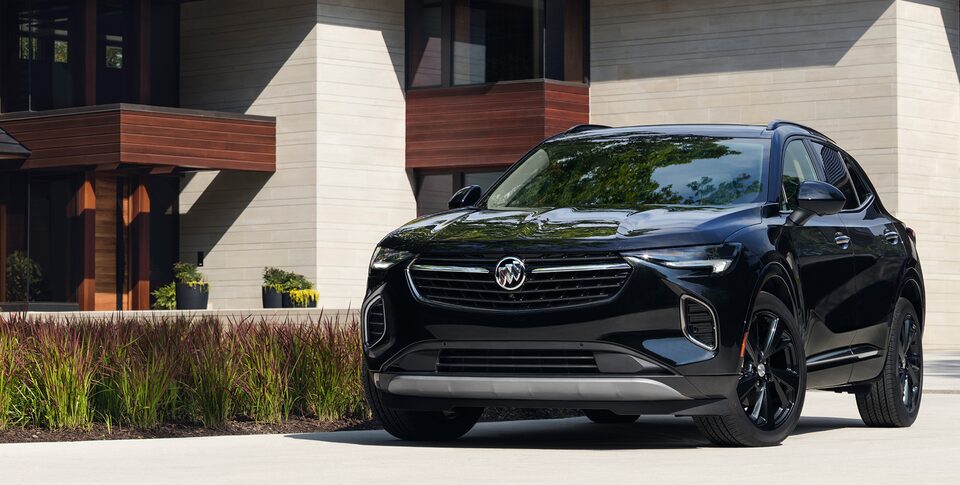 Profil avant du Buick Envision 2023 groupe sport de tourisme stationné devant une maison.