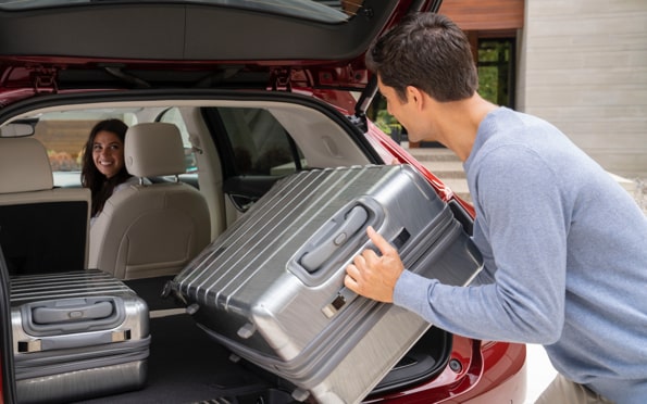 Un homme qui dépose ses bagages dans le coffre de l’Envision 2022.