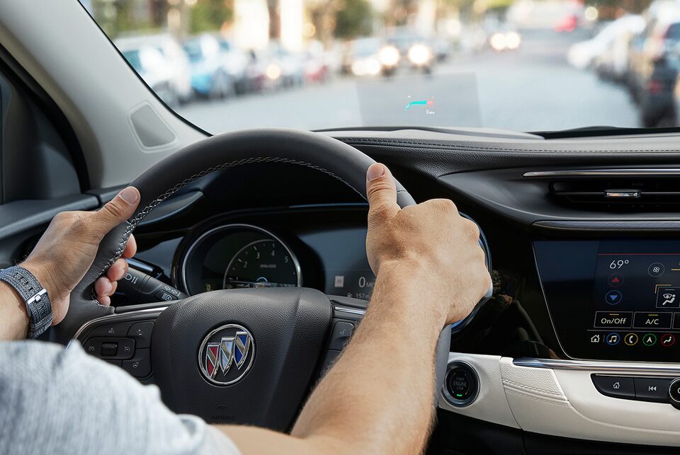 Homme tenant le volant de l'Encore GX 2022.