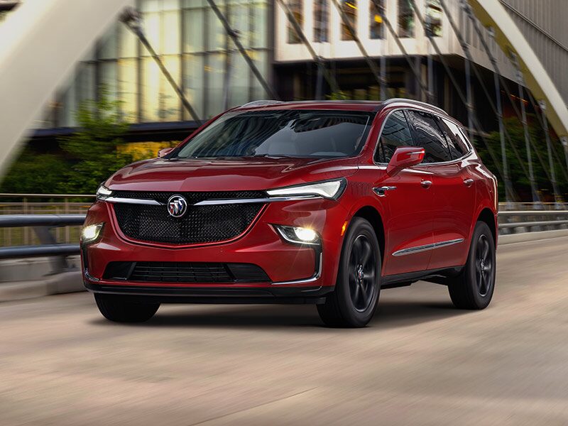 2024 Buick Enclave Sport Touring driving with its headlamps on.
