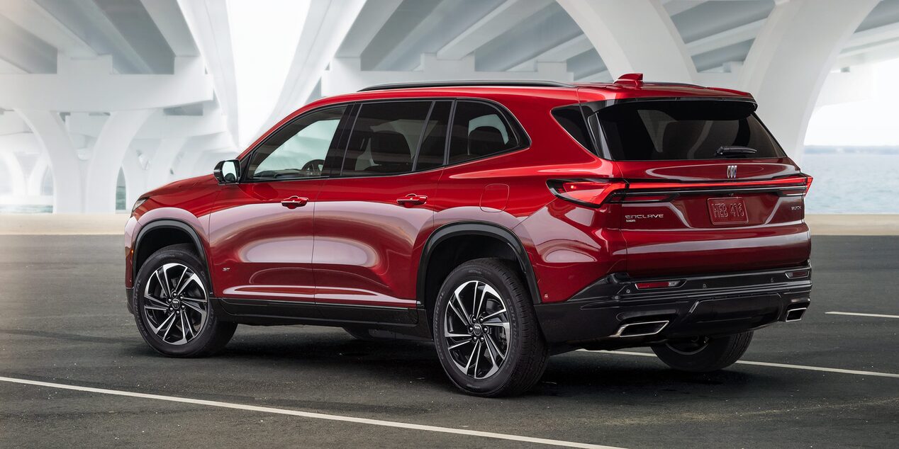Vue latérale arrière du Buick Enclave ST 2025 stationné sous un pont pendant une matinée ensoleillée.