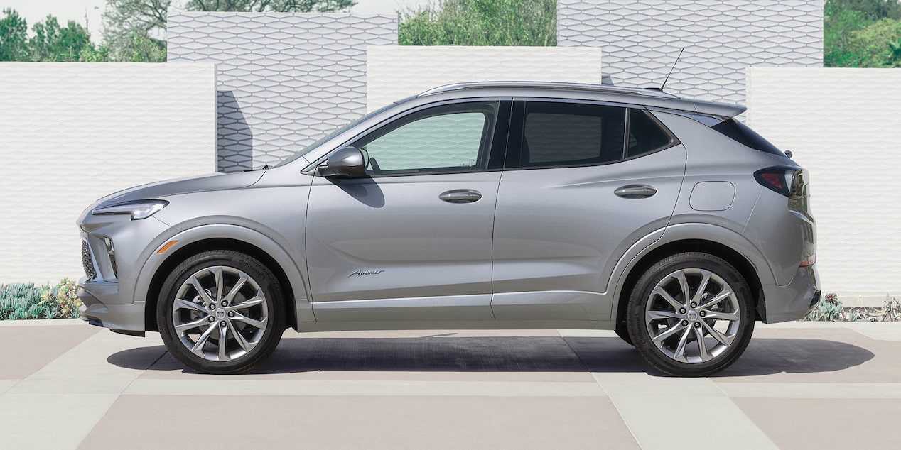 Vue latérale du Buick Encore GX Avenir 2025 stationné devant des blocs.
