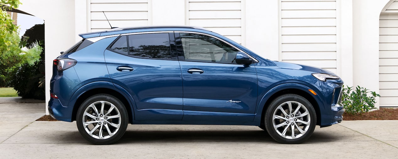 Vue latérale du Buick Encore GX 2025 stationné devant une maison moderne.