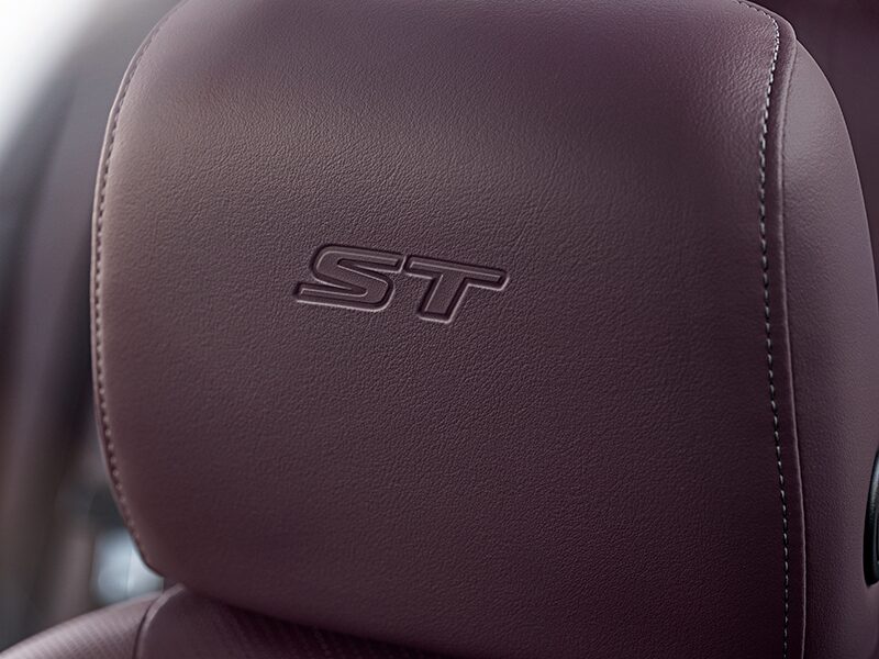 Vue rapprochée de l’emblème ST cousu sur un appuie-tête du VUS compact sportif Buick Envision ST 2025.