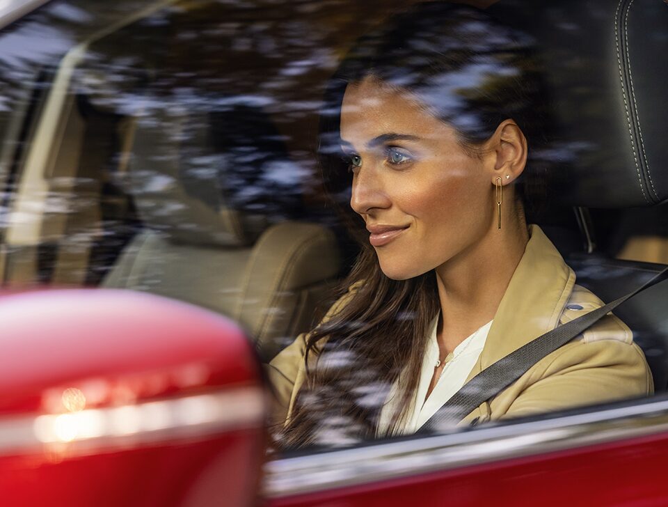 Woman driving the 2022 Buick Enclave with QuietTuning technology.
