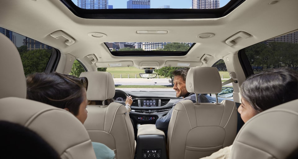 A family inside a 2022 Buick Enclave with moonroof open.