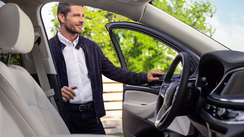 Man opens the driver-side door of the 2022 Buick Enclave.