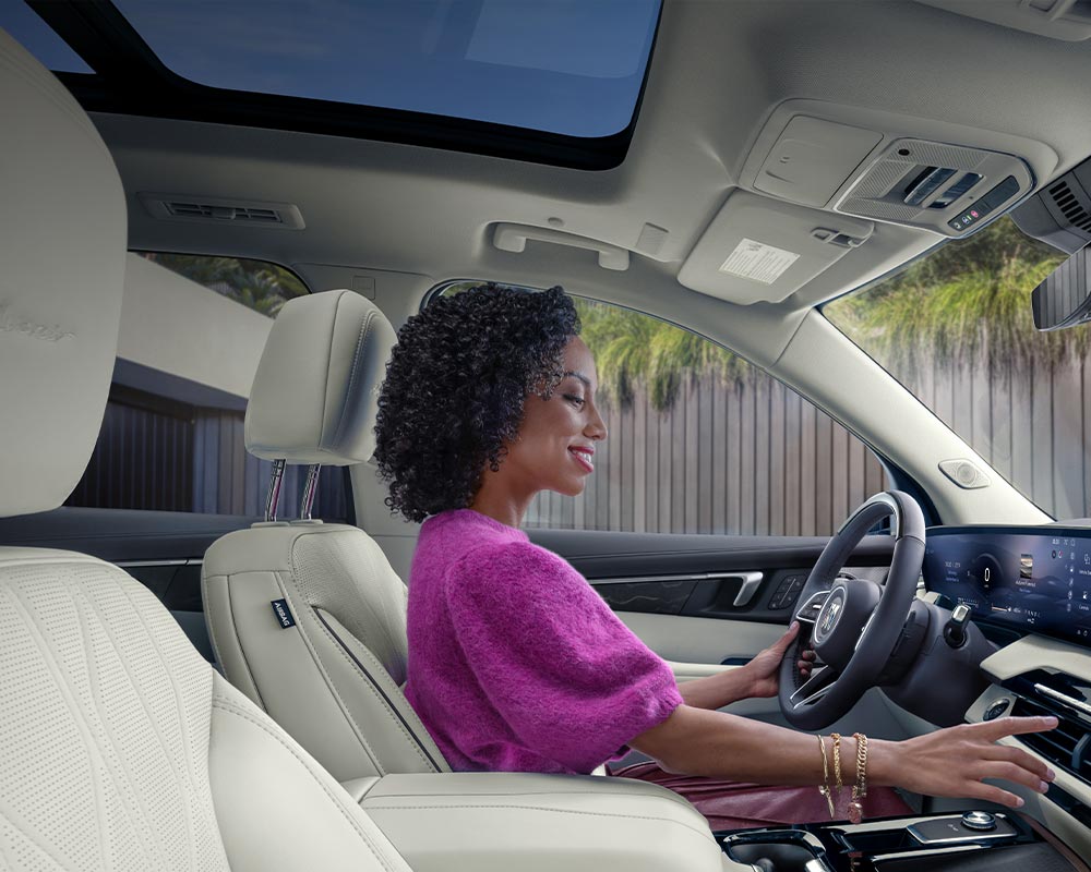 Une vue intérieure des sièges arrière blancs d’une Buick Enclave Avenir 2027 avec toit ouvrant panoramique.