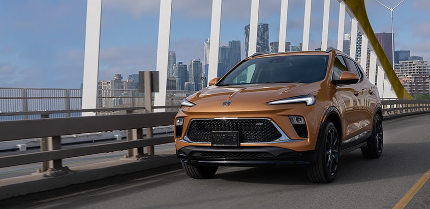 Un VUS Buick couvert par un plan de protection GM en mouvement seul sur un pont.