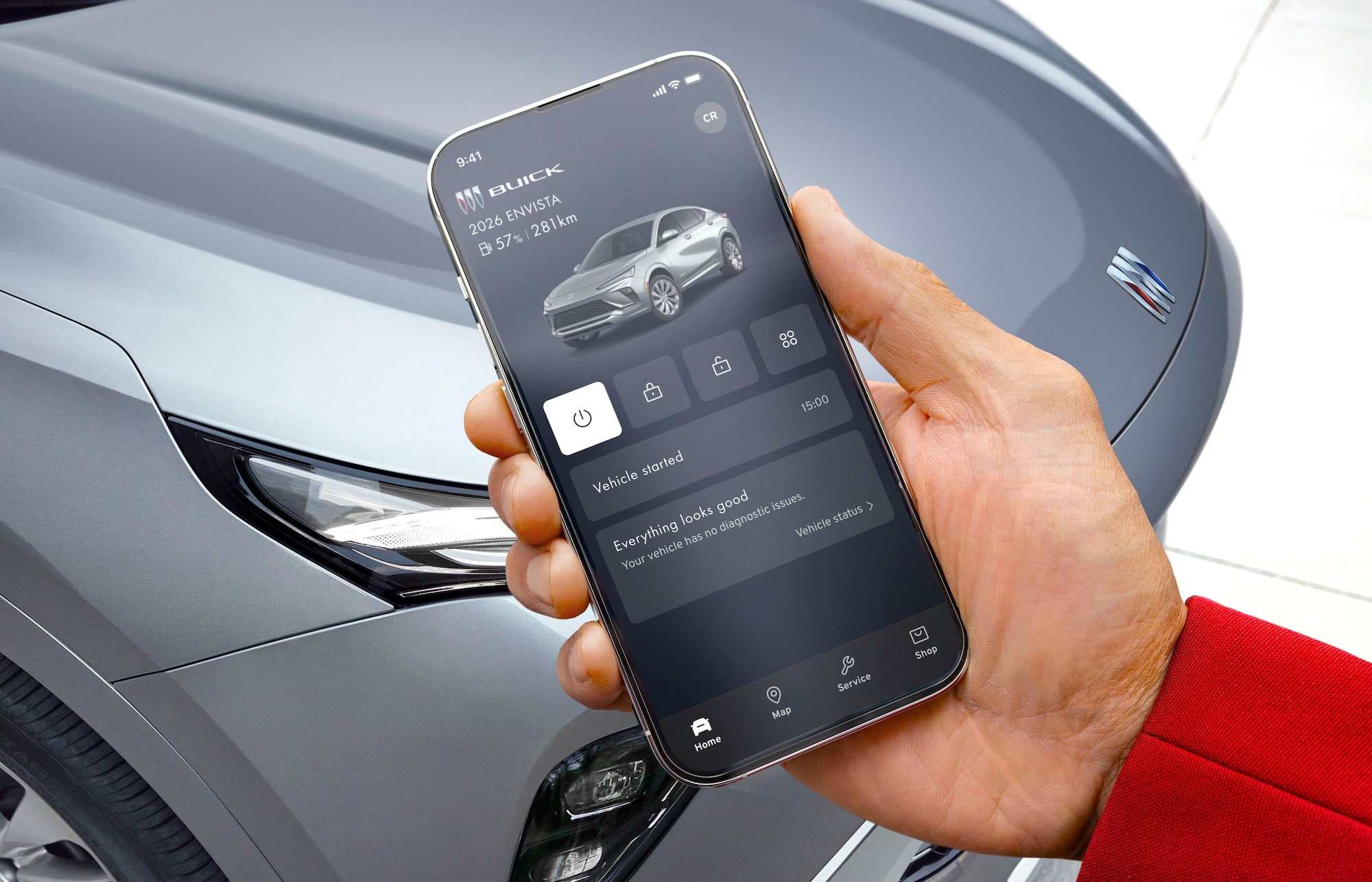 A person using a smartphone near an OnStar-subscribed Buick vehicle.
