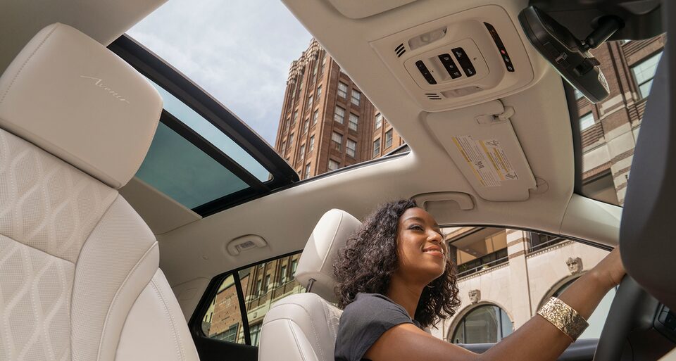 Woman driving the 2022 Envision featuring the panoramic moonroof.