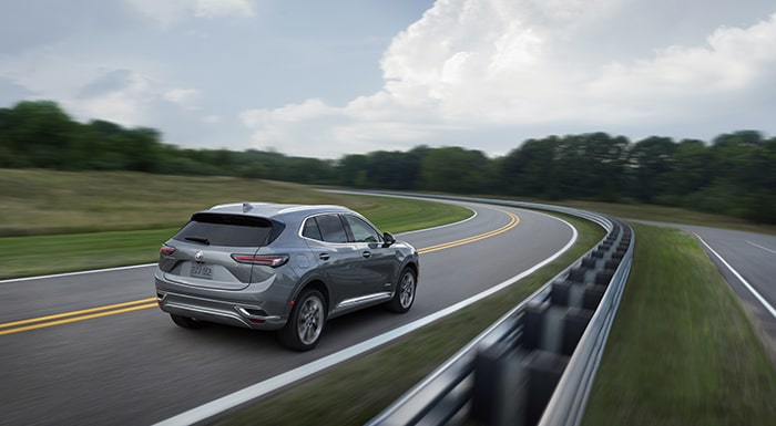 Back view of the 2023 Buick Envision driving on the road.