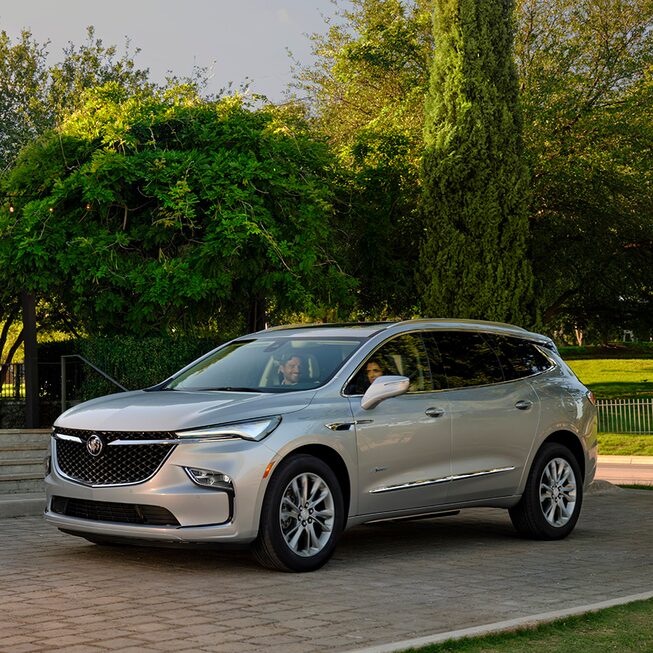 2023 Buick Enclave Avenir mid-size SUV parked outside a home.