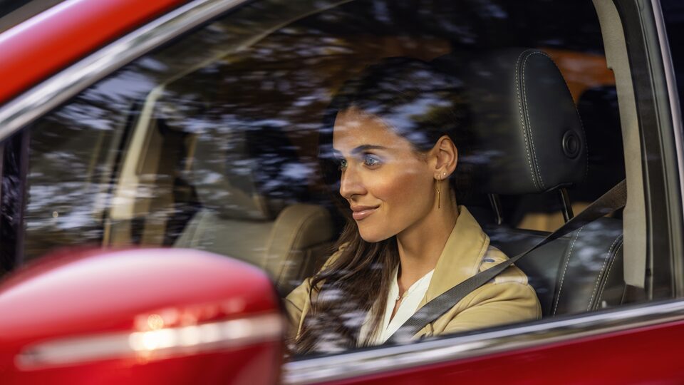 Woman driving the 2023 Buick Enclave with QuietTuning technology.