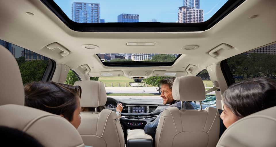 A family inside a 2023 Buick Enclave with moonroof open.