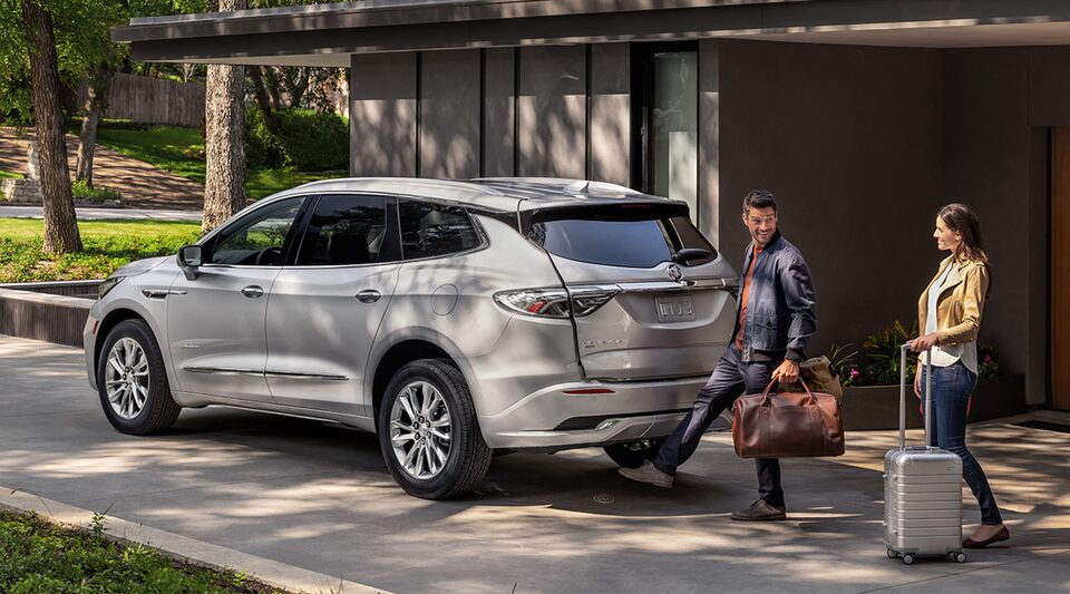 Un couple qui active le hayon mains libres du Buick Enclave 2023.