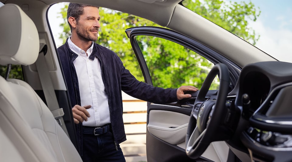 Un homme ouvre la portière côté conducteur du Buick Enclave 2023.