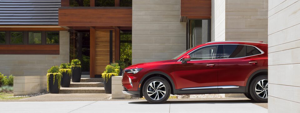 Profil latéral du Buick Envision 2023 stationné devant une maison.