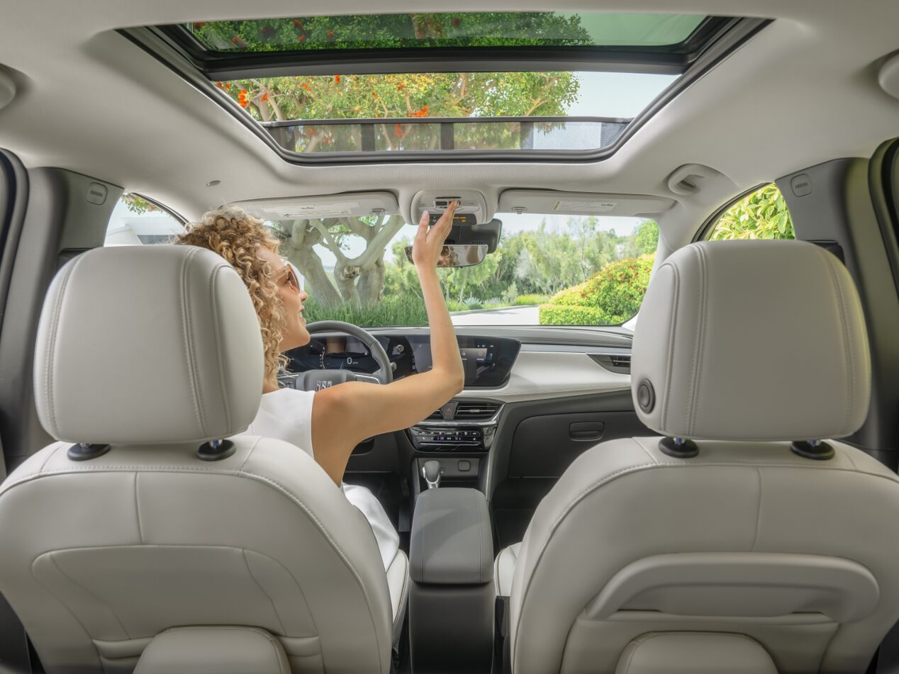 Une femme au volant de l’Encore GX 2024 vue par les passagers arrière.