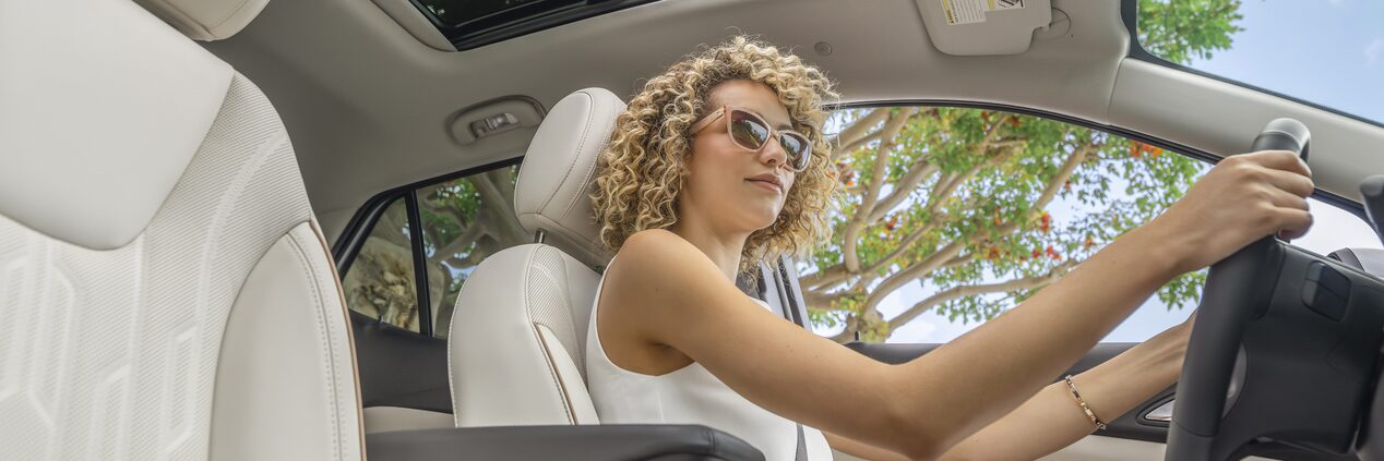 Une femme au volant d’un Encore GX 2024.