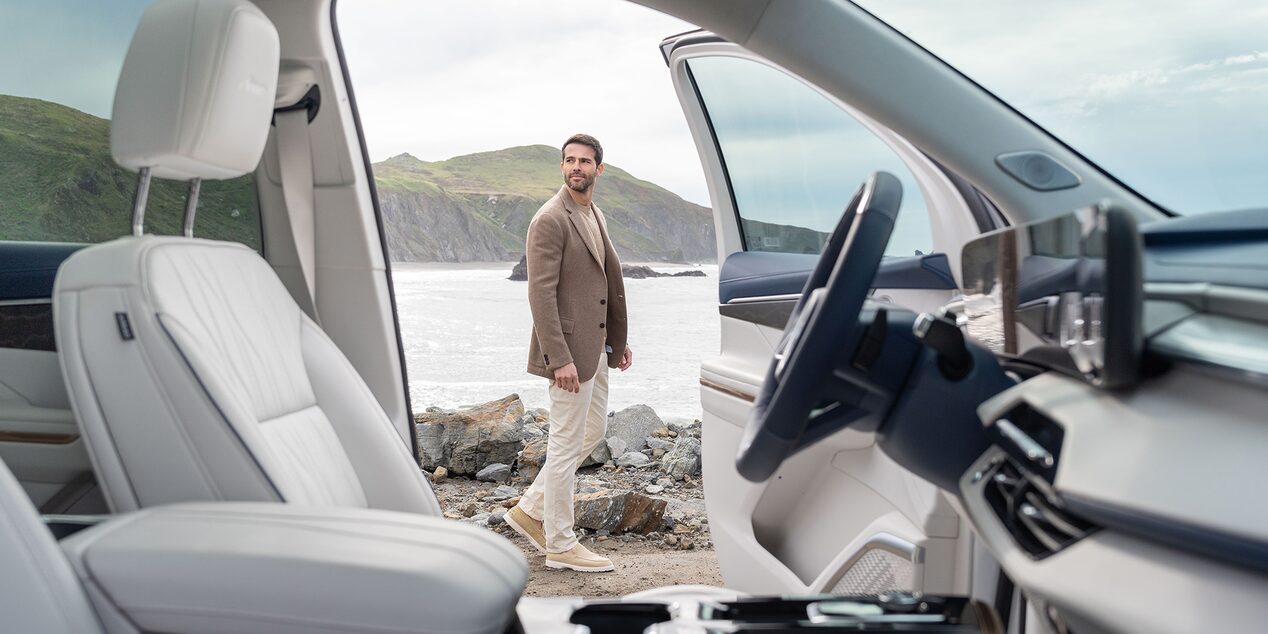 Driver's door opened inside the 2025 Buick Enclave as a person passes by.