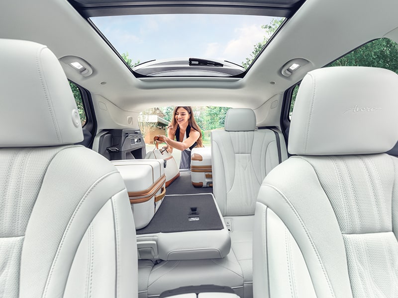 Interior View of a 2025 Buick Envision Avenir Compact Luxury SUV with a Person loads luggages Into the Trunk.