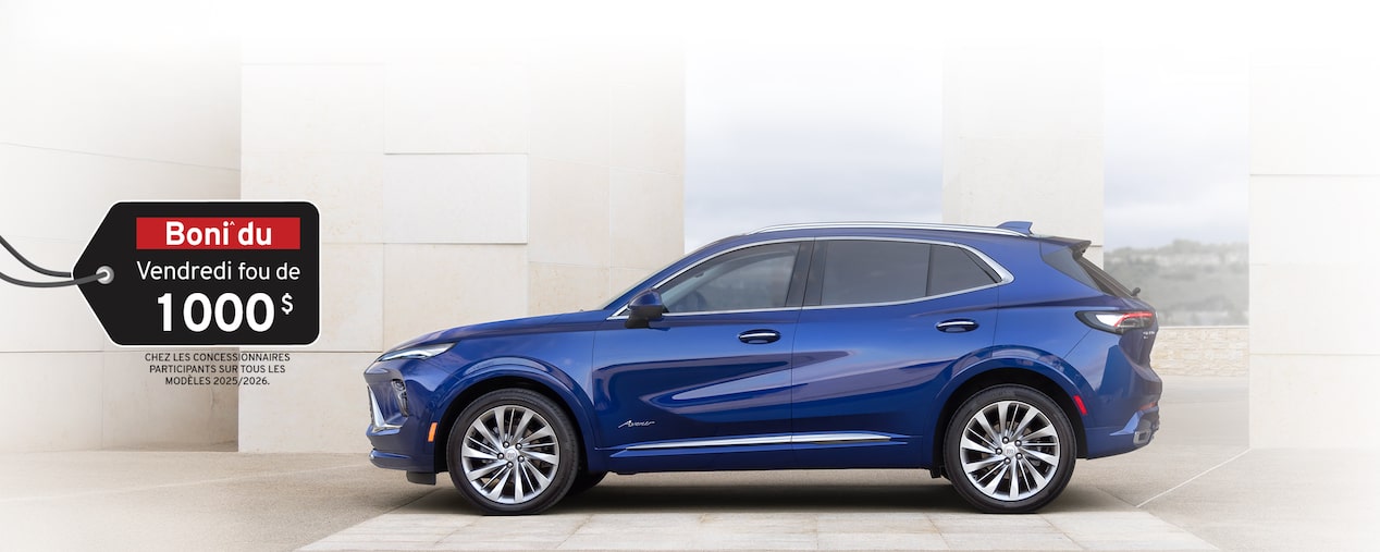 Vue latérale avant du VUS compact Buick Envision 2025 stationné devant un bâtiment.