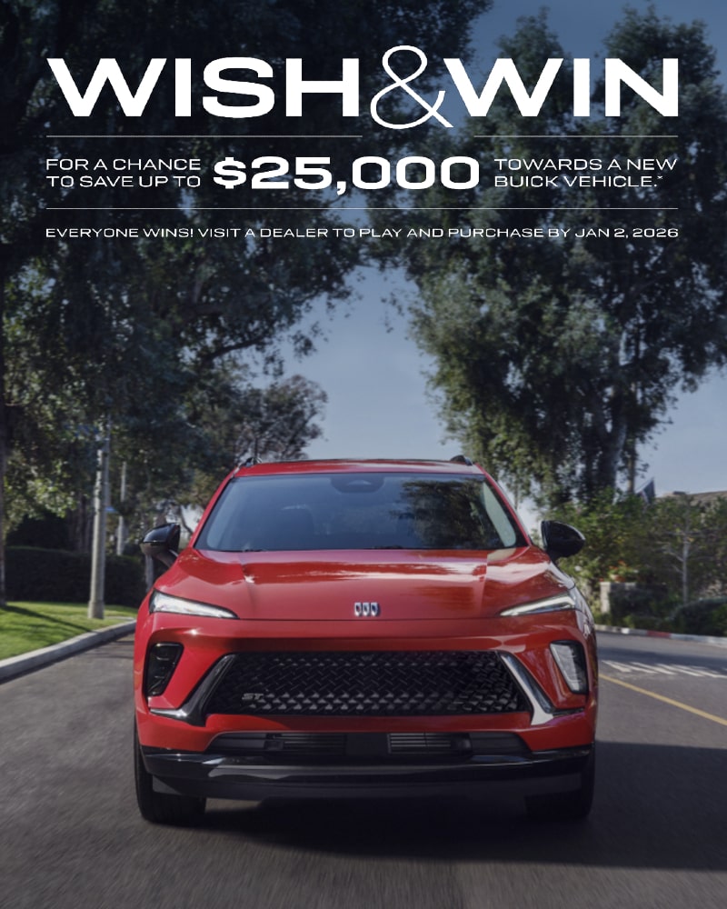 Front Three-Quarters View of a 2025 Buick Envision Compact SUV Parked in Front of a Building.