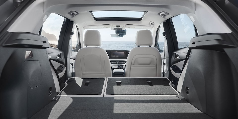 Vue arrière de l’habitacle du petit VUS Buick Encore GX 2026 avec les sièges arrière rabattus.