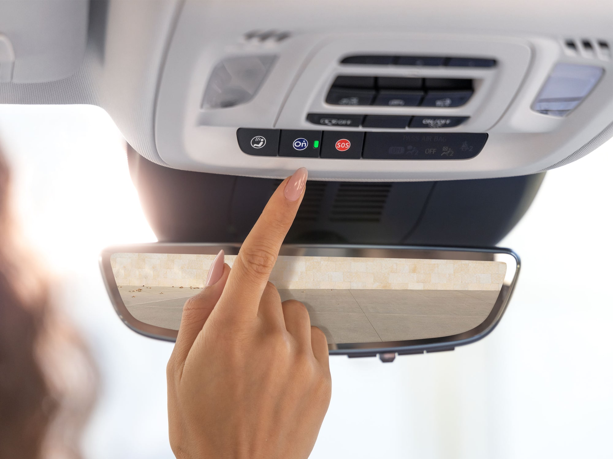 Close-up of a Driver Pressing the Blue OnStar Button in her Vehicle