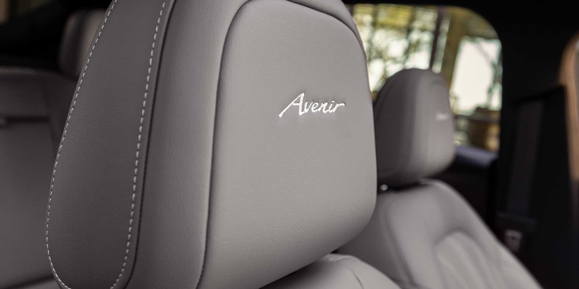 Vue rapprochée du logo Avenir gravé sur l'appui-tête du siège du Buick Envista Avenir 2026.
