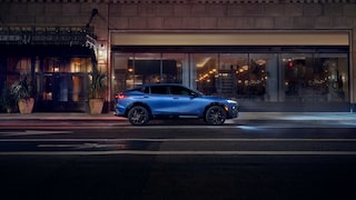 Vue latérale de la Buick Envista 2026 stationnée à côté d’un bâtiment la nuit.