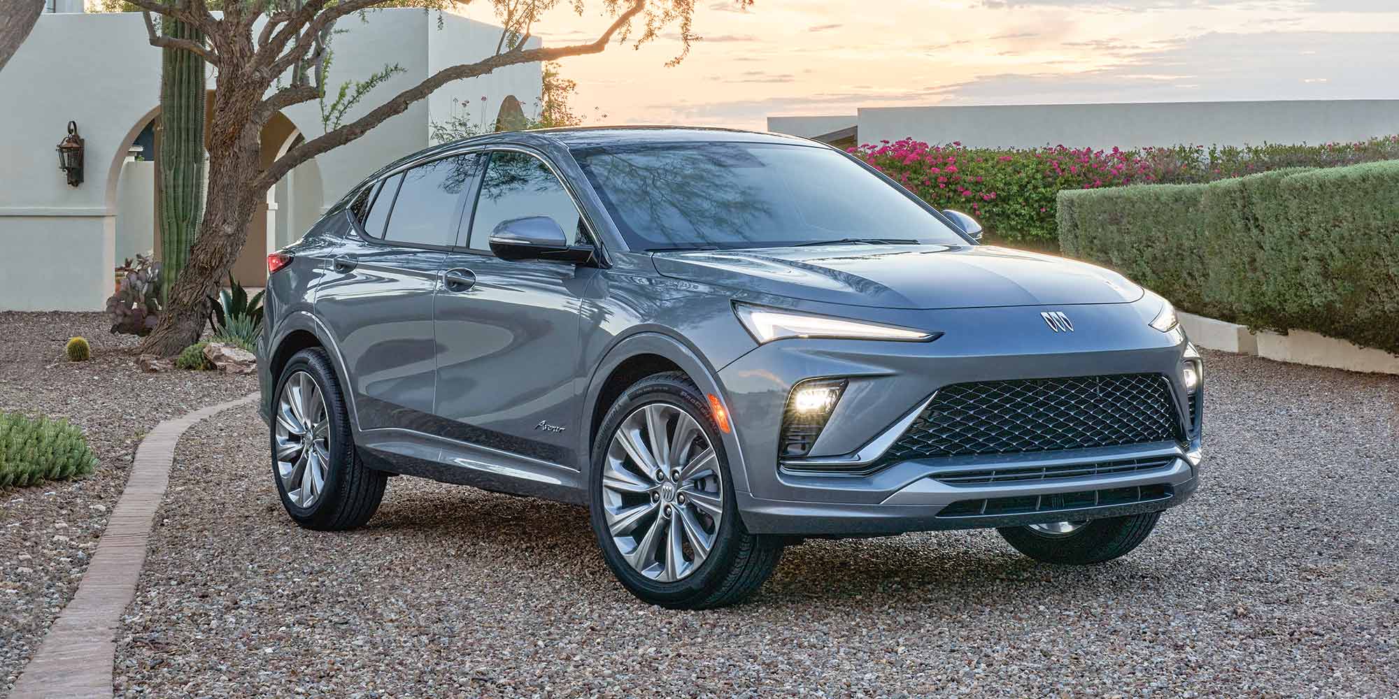 La Buick Envista 2026 stationnée en extérieur avec son phare allumé.