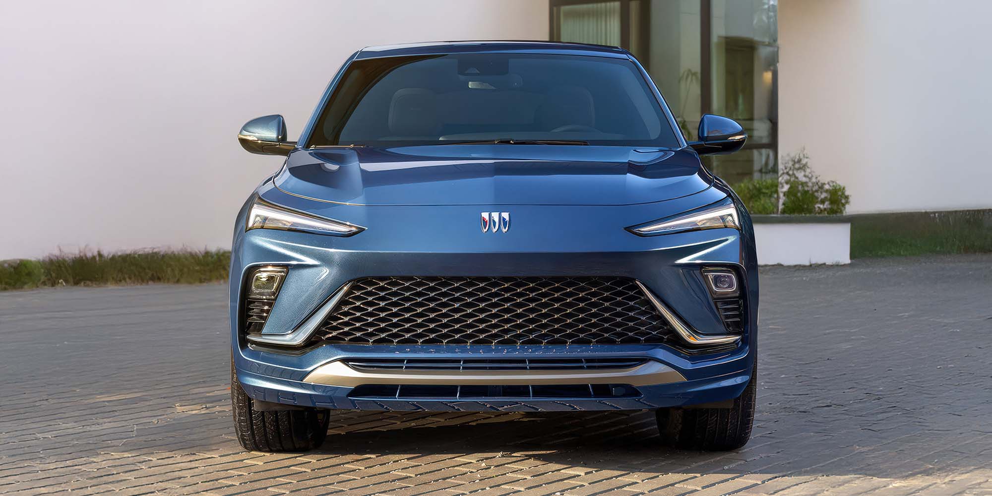 La Buick Envista 2026 stationnée en extérieur avec son phare allumé.