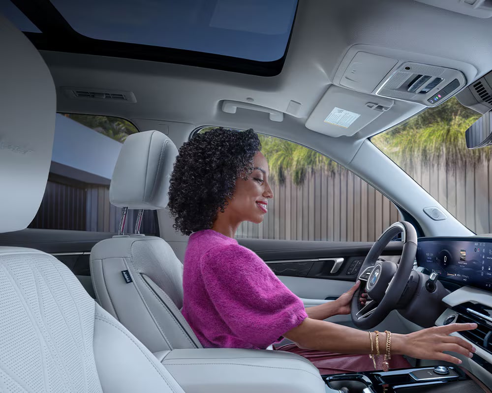 Une vue intérieure des sièges arrière blancs d’une Buick Enclave Avenir 2027 avec toit ouvrant panoramique.