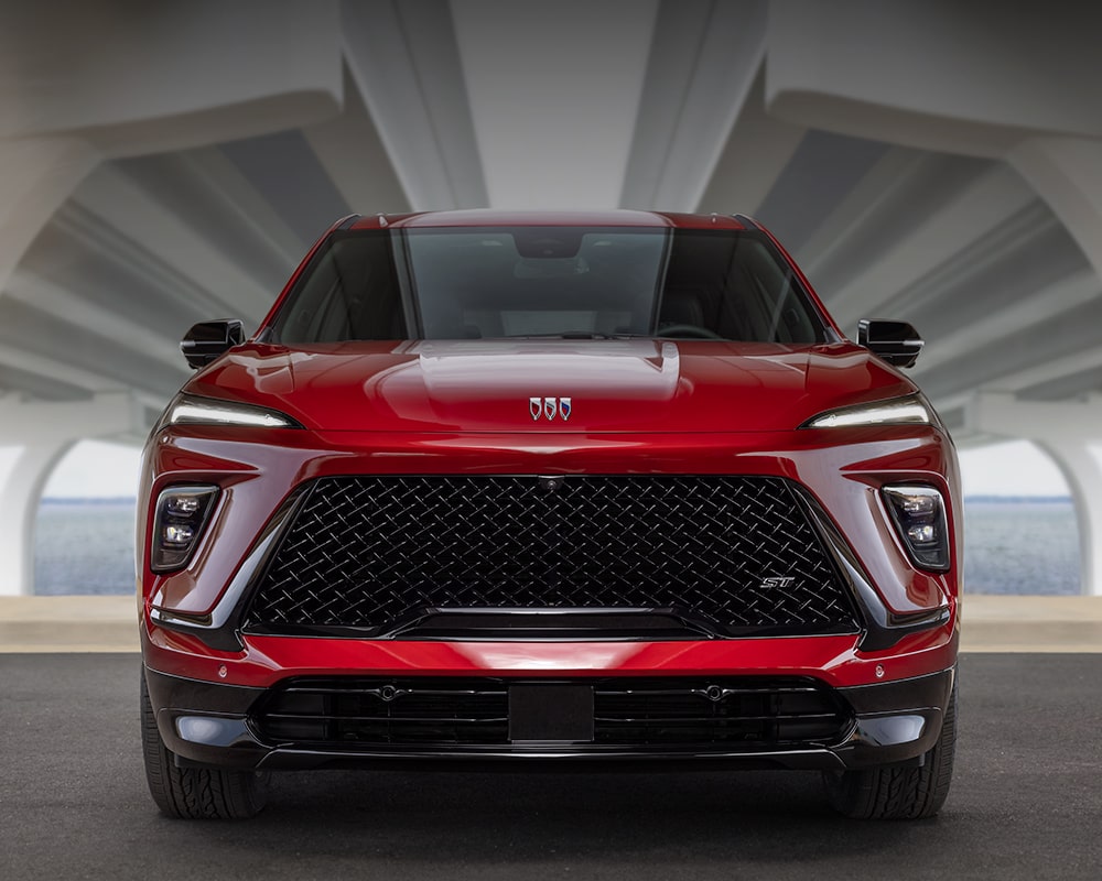 Vue de face d’un VUS Buick Enclave ST rouge 2027 sous un viaduc.