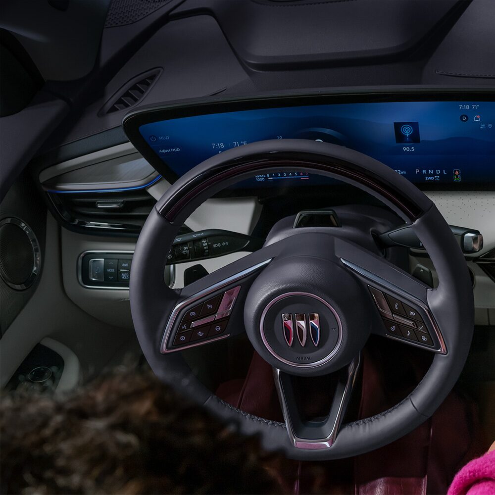 Un gros plan d’un volant en cuir noir avec des accents argentés à l’intérieur de la Buick Enclave 2027.