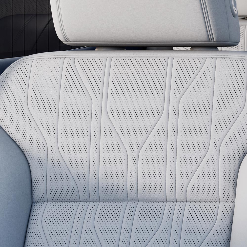 A Close-Up View of a White Perforated Leather Car Seat with Intricate Stitching inside the 2027 Buick Enclave Avenir.