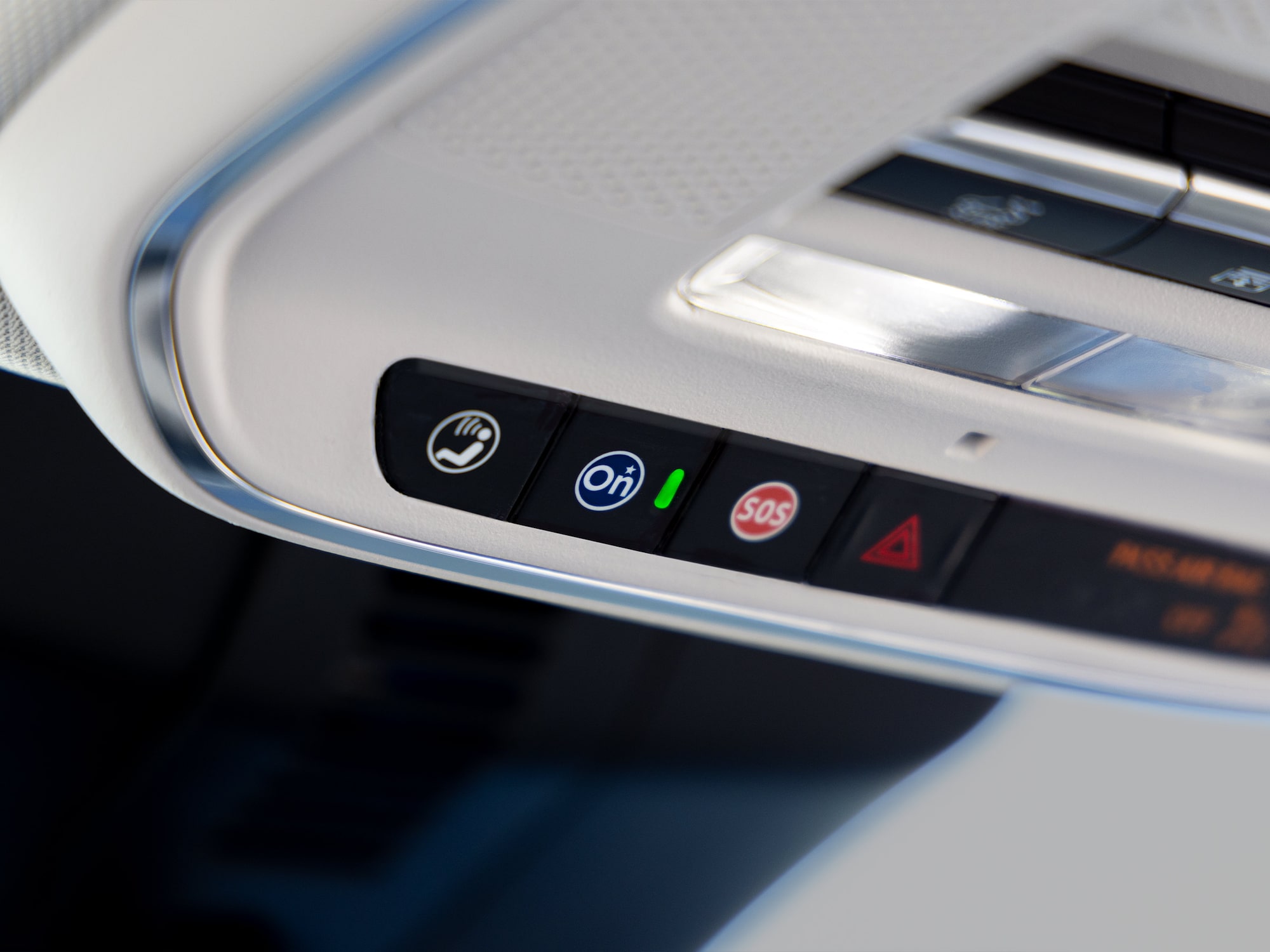 A Close-up of a 2027 Buick Enclave Avenir Car's Overhead Console with OnStar SOS and Hazard Warning Buttons.