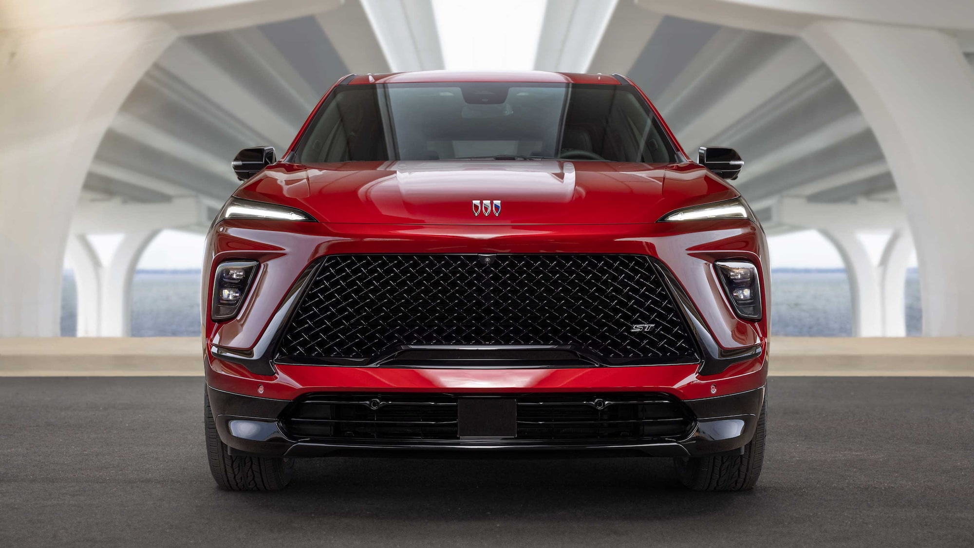 Vue de face d’un VUS Buick rouge 2027 avec une grande calandre noire et des phares à DEL élégants