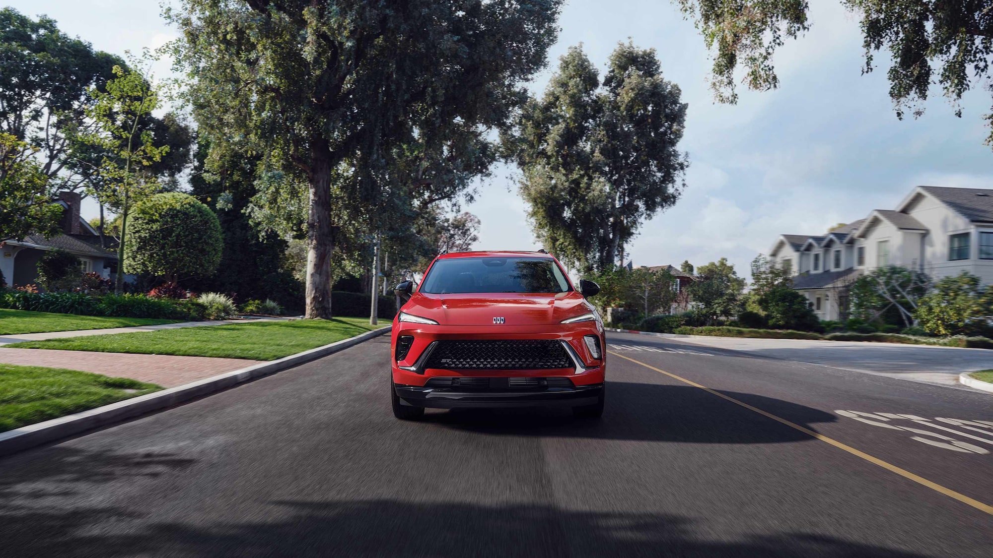 Vue avant du Buick Envision ST 2026 en mouvement sur une route asphaltée.