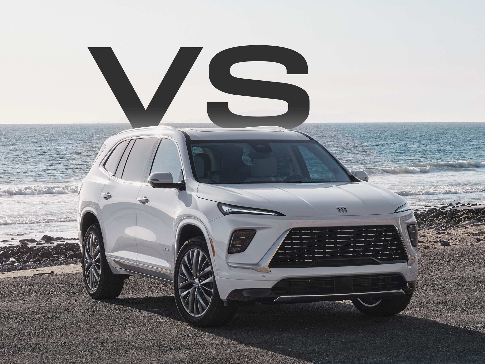 Front Three-quarters View of a White Buick Enclave Parked on a Beach as Waves Crash on the Shoreline