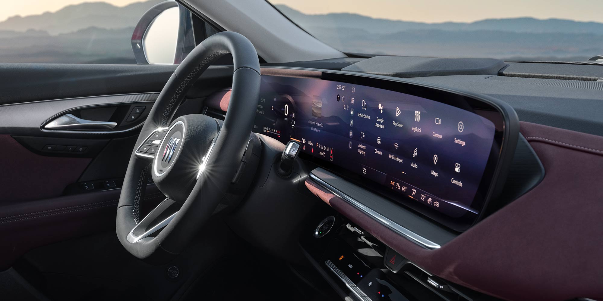 A Detailed View of the 2025 Buick Envision Interior with a Large Infotainment Screen and Steering Wheel at Dusk
