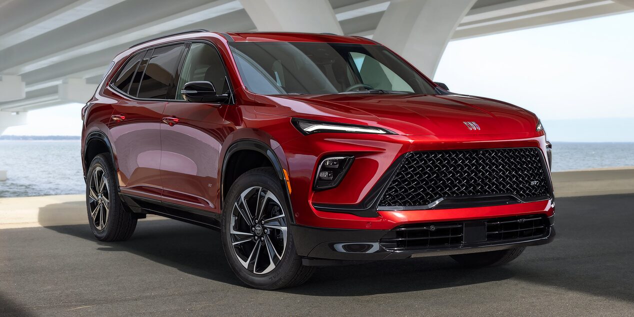 A Vibrant Red Buick Enclave SUV Parked Under a Concrete Bridge Next to the Water
