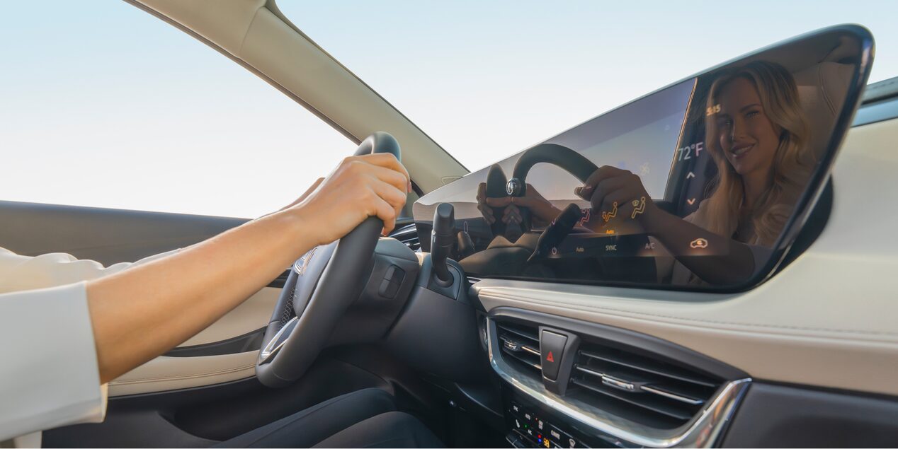 Interior View of  the Buick Infotainment Screen as a Woman Holds onto the Steering Wheel