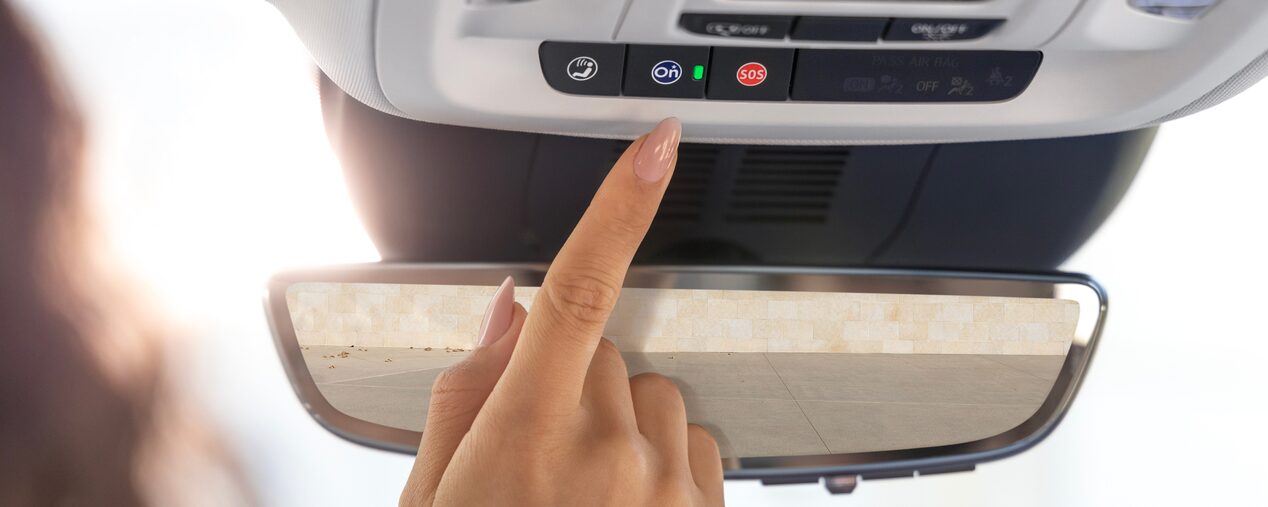 Close-up of a Woman Pressing the OnStar Button in her Vehicle