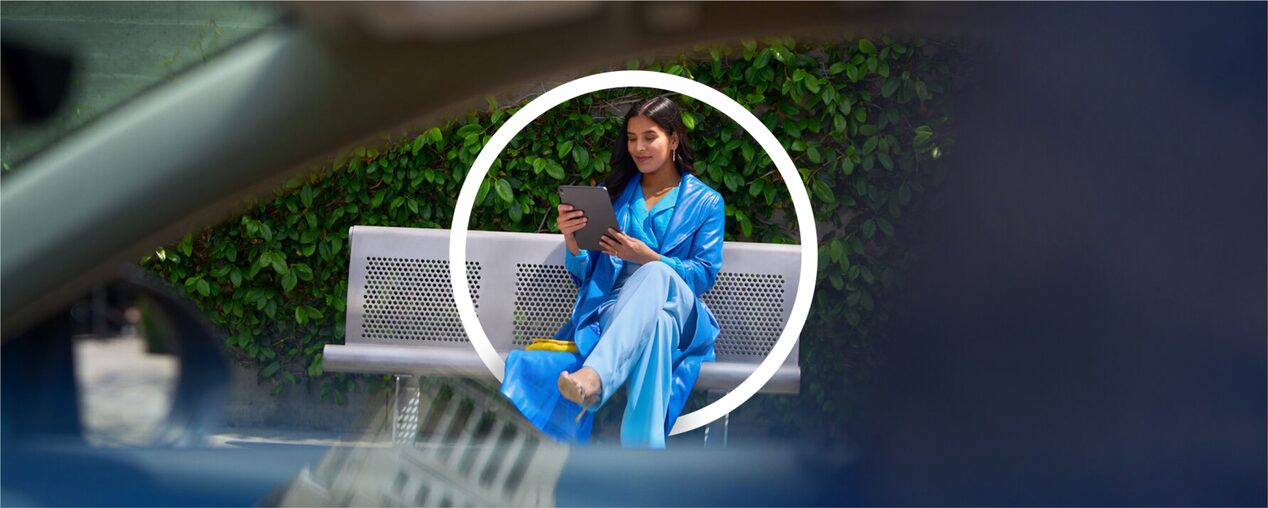 A Woman Sitting on a Park Bench Using her iPad