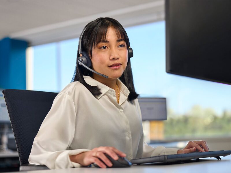 An OnStar Advisor with a Headset on Sitting at a Computer and Ready to Assist OnStar Customers