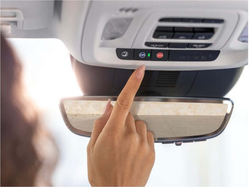 Close-up of a Woman Pressing the OnStar Button in her Vehicle