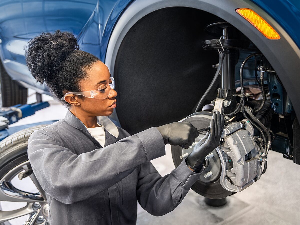 A Mechanic Is Working on the Wheel of a Suspended Vehicle